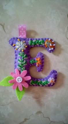 the letter e is decorated with flowers and beads