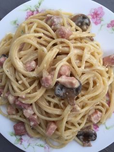 a white plate topped with pasta and mushrooms