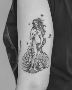 a black and white photo of a woman's tattoo on the left upper arm