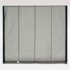 a white curtain with black trim hanging on a wall in front of a gray background