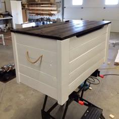 a large white box sitting on top of a black dolly in a room filled with tools