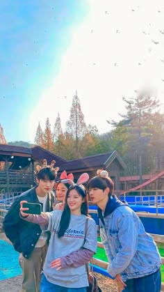 four people posing for a photo in front of a water park