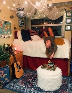 a man laying on top of a bed in a room with lots of lights hanging from the ceiling