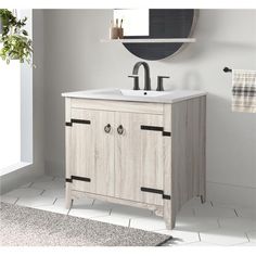 a bathroom with a sink, mirror and towel rack on the wall next to it