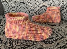 two knitted slippers sitting on top of a couch