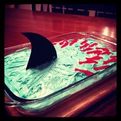 an ice cream dish is decorated with red and blue icing in the shape of a shark fin