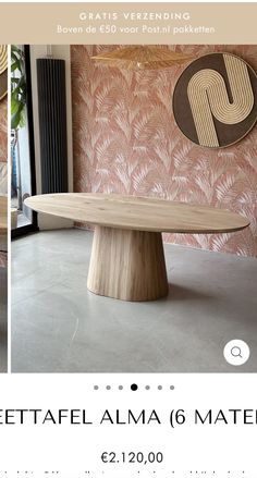 a wooden table sitting in front of a pink wall