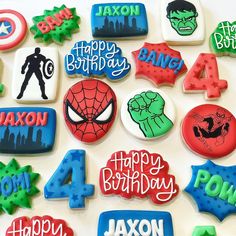 decorated cookies with the names of birthdays and superhero characters are displayed on a white surface