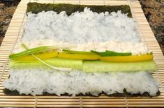 a bamboo mat topped with rice and veggies on top of eachother