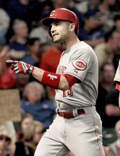 a baseball player holding a bat in front of a crowd at a game with people watching