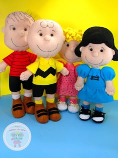 three stuffed dolls are standing next to each other in front of a yellow background and blue backdrop