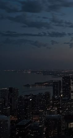 the city lights shine brightly at night in this view from top of a skyscraper building