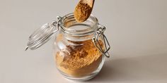 a jar filled with brown powder and a wooden spoon sticking out of it's top