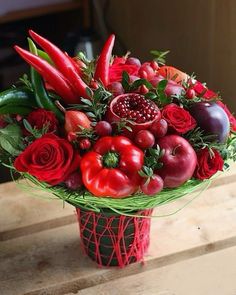 a red vase filled with lots of fresh fruit and vegetables