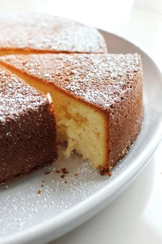 a cake that has been cut into pieces on a plate with powdered sugar around it