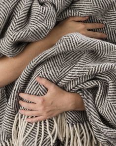 a woman wrapped in a blanket with her hands on her stomach