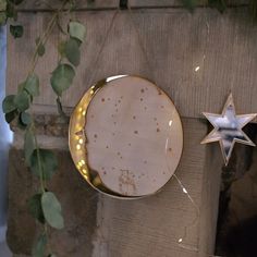 a white plate with gold stars on it next to a silver star ornament