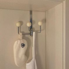 a pair of white gloves hanging on a hook in a room with two lights above it