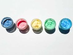 four jars filled with different colors of paint