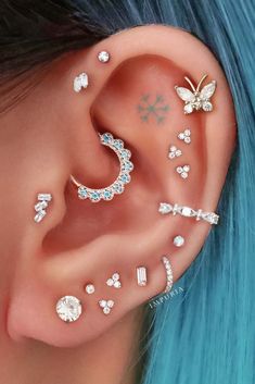 a woman with blue hair and piercings on her ear is wearing an ear cuff