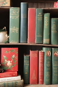 several books are stacked on top of each other in a bookcase with christmas decorations