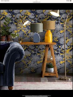 a blue couch sitting next to a wooden table with two lamps on top of it