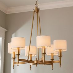 a chandelier with six lamps hanging from it's sides in a living room