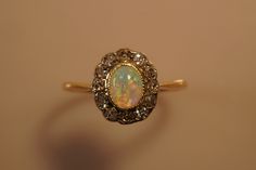 This fabulous ring is a wonderful example of fine Victorian jewellery--and I hate to see it go! It has a glowing blue/green & pink opal and it is surrounded and enhanced by 13 rose cut diamonds. Set in 18ct yellow gold (Stamped 18ct) yellow gold. Ring size 16.4mm internally or size L1/2 -- can be sized by any good local jeweller.  Looks gorgeous on the handjust enough sparkle without being gaudy. This is a Rare & Beautiful Antique opal with some wear to the opal on the side under the setting so Antique Opal Ring, Victorian Jewellery, Antique Jewelry Rings, Old Rings, Ring Opal, Antique Ring, Victorian Jewelry, Opal Ring, Pink Opal