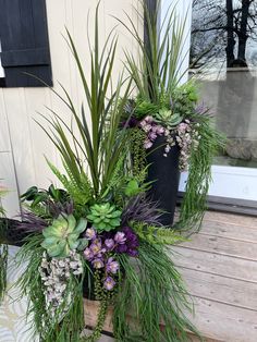 a planter filled with plants sitting on top of a wooden bench next to a door