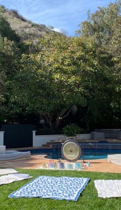 there is a pool in the back yard with towels on the ground and an umbrella over it