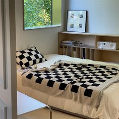 a black and white checkered comforter on a bed in a room with a window