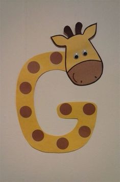 a giraffe and letter g made out of paper on a wall in a child's room