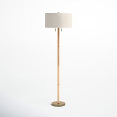 a wooden floor lamp with a white shade