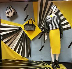 mannequin dressed in black and white striped shirt, yellow skirt and handbag