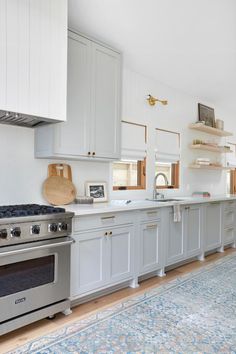 a kitchen with an oven, stove and rug on the floor in front of it