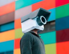 a man in front of a multicolored wall with a camera on his head