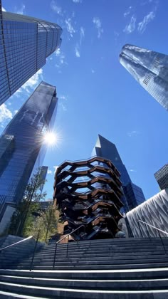 the sun shines brightly in front of some tall buildings on a sunny day with steps leading up to them