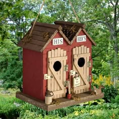 a red birdhouse with two doors that say his and hers