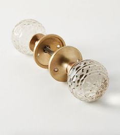 two glass door knobs on a white surface