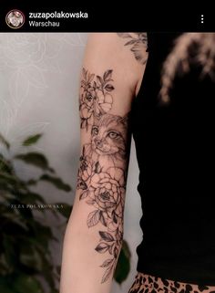 a woman's arm with flowers and a cat on it