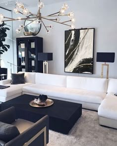 a living room with white couches and black tables