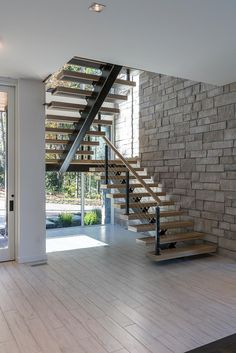 an empty room with stairs leading up to the second floor and glass doors on both sides