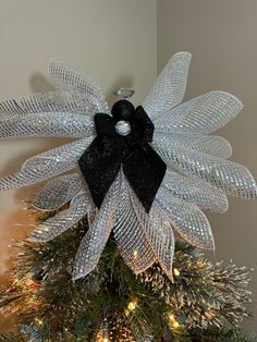 a black and white bow on top of a christmas tree