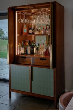 a wooden cabinet filled with lots of bottles and glasses