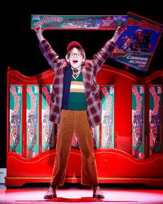 a man standing on top of a stage with his arms in the air while holding up a sign