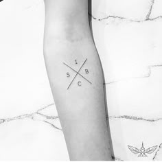 a black and white photo of a person's arm with a cross tattoo on it