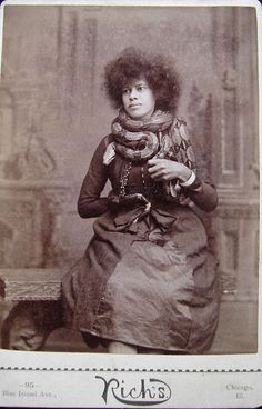 an old black and white photo of a woman with curly hair sitting on a bench