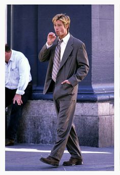 a man in a suit and tie walking down the street