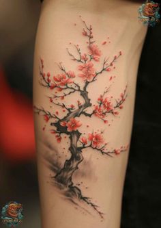 a woman's arm with a tree and flowers tattoo on the left side of her leg