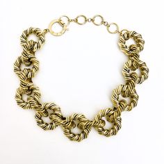 An elegant display of twisted metal links in gold color Hip Hop style. Modern Chunky Chain Link Jewelry, Metal Jewelry With Modern Twist Chain, Modern Twist Metal Chain Jewelry, Modern Chunky Link Jewelry, Chic Metal Link Choker, Modern Metal Chain Jewelry, Chic Metal Chain Choker, Bold Gold Chain Jewelry, Modern Metal Choker With Chunky Chain